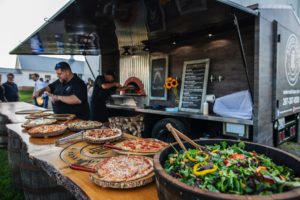 Farm to table catering spread including wood fired pizza and salad